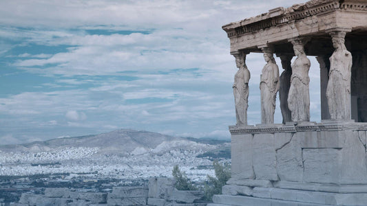 Ancient Greek temple overlooking a city with female statues