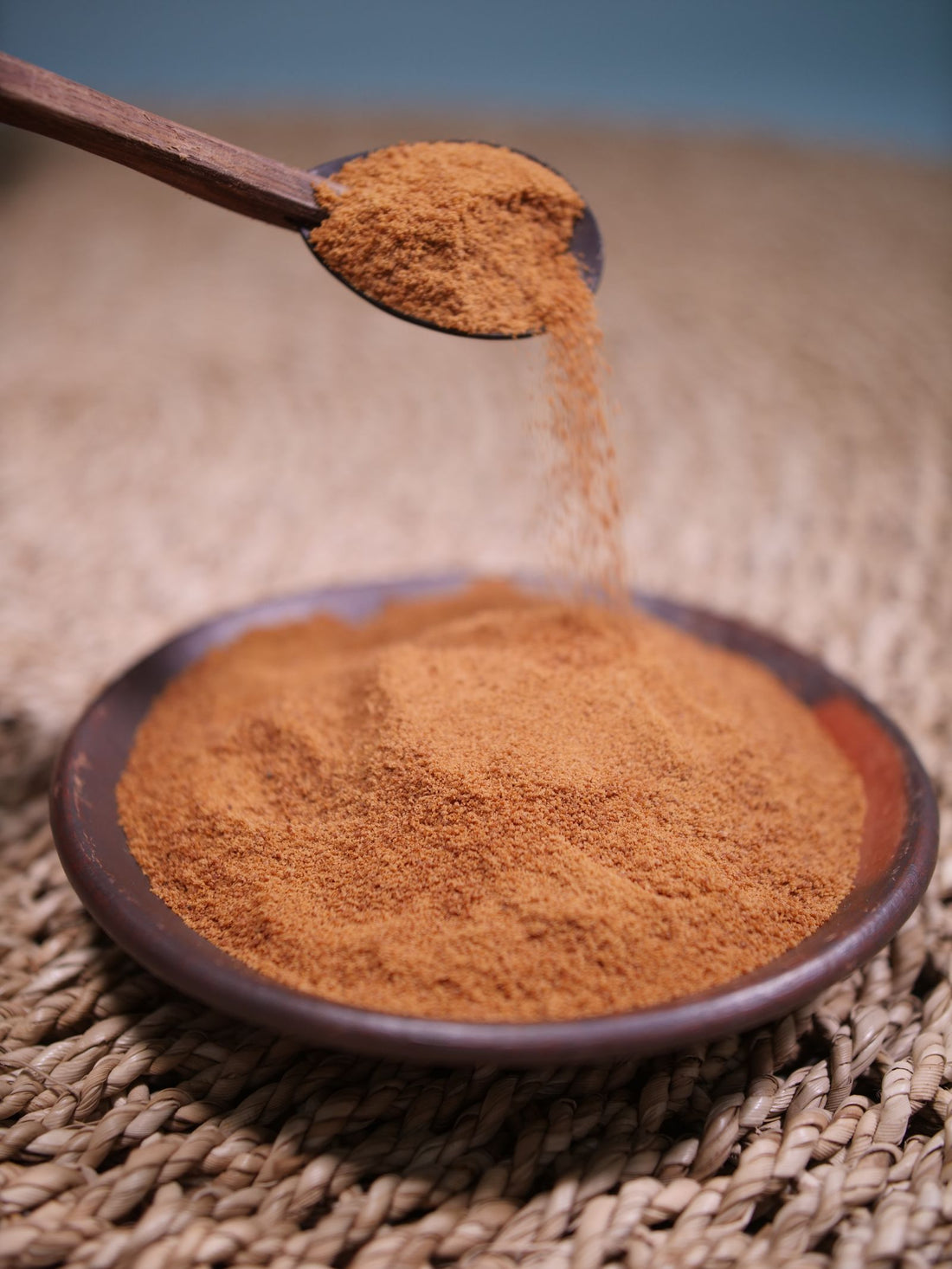 Finely ground brown mushroom powder in a shallow wooden bowl