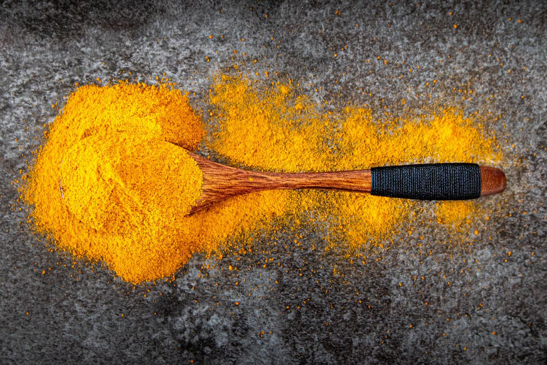 Turmeric powder spread with a wooden spoon