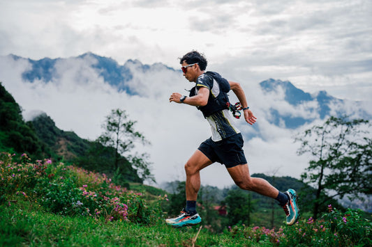 A trail runner moving along a mountain ridge in morning light