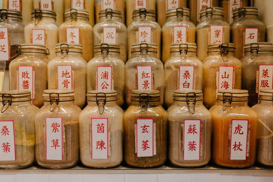 Rows of labelled apothecary jars on a wooden shelf