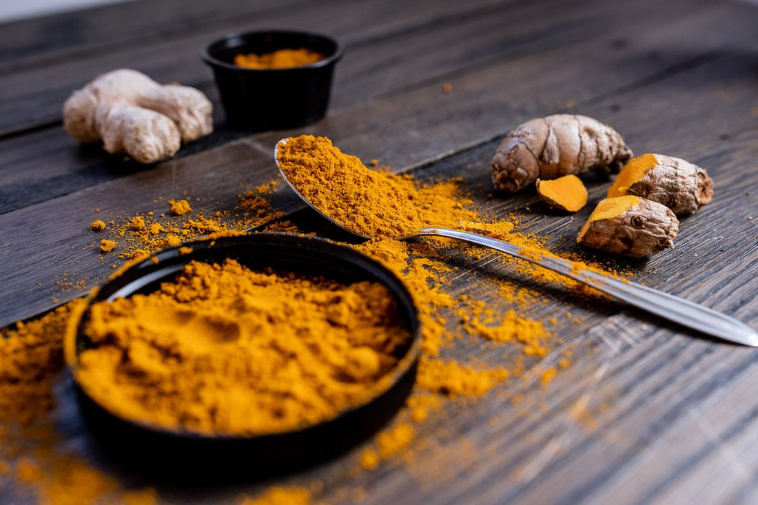 Turmeric root and powder on a rustic wooden surface