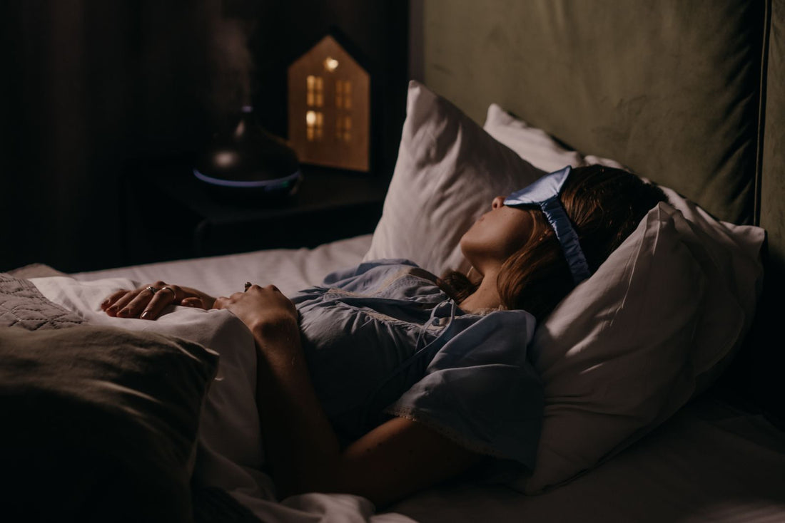 A person resting in a dimly lit bedroom at night