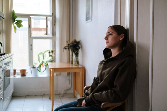 A person sitting by a window looking tired and unfocused