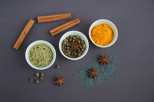 Assorted spices in white ceramic bowls, as used in traditional Indian cooking and Ayurveda