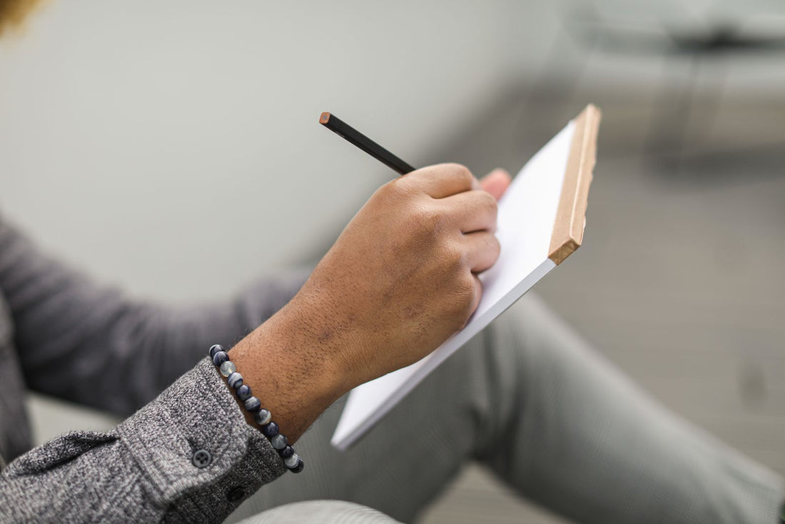A person writing notes in a small notebook