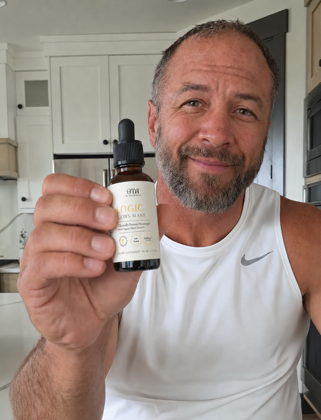 A hand holding a bottle of Logic Lion's Mane liquid mushroom supplement